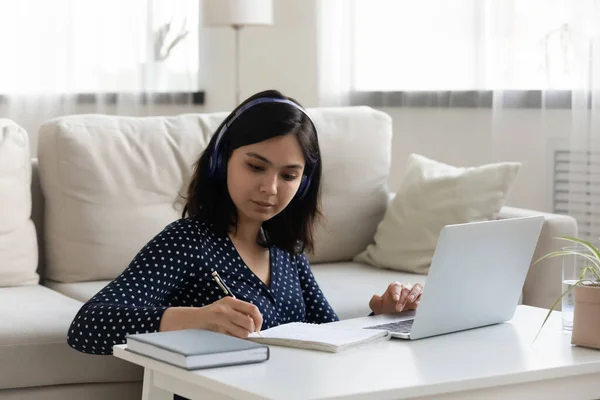 Focalizzato giovane donna coreana vietnamita ascolto lezione educativa. — Foto Stock