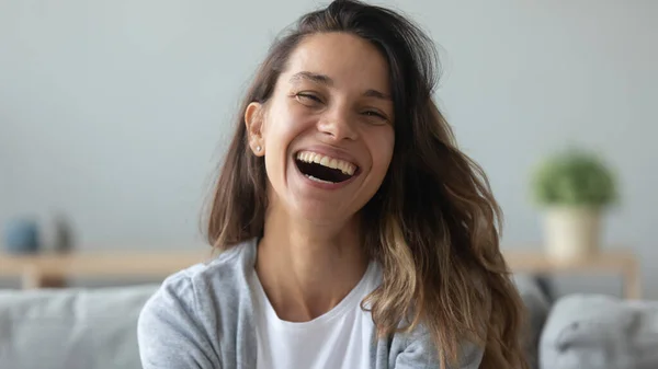 Close up overjoyed woman laughing, sitting on couch at home — Stock Photo, Image