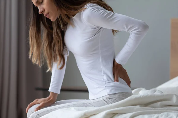 Fechar a mulher infeliz esfregando os músculos rígidos das costas após o despertar — Fotografia de Stock