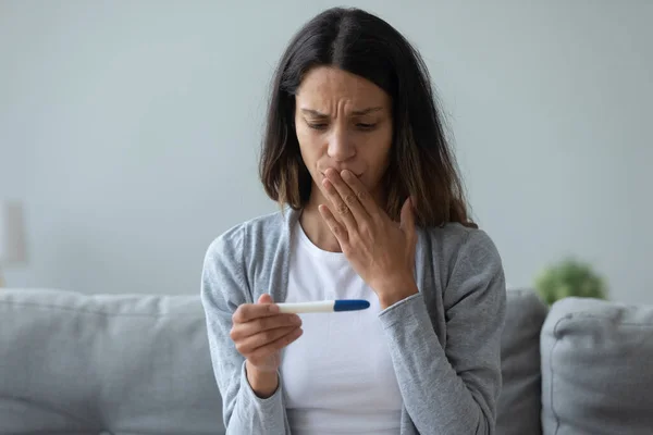 Close up unhappy woman holding pregnancy test, shocked by result — Stock Photo, Image