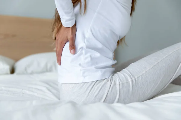 Fechar a mulher exausta tocando os músculos tensos das costas após o despertar — Fotografia de Stock