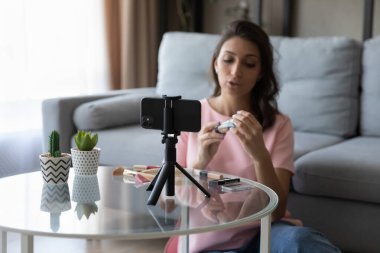 Etnik kadın blogcu cep telefonunda makyaj dersi çekiyor