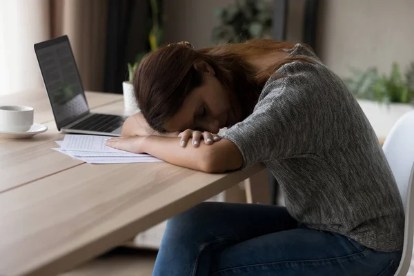 Уставшая женщина засыпает за столом, работая за компьютером — стоковое фото