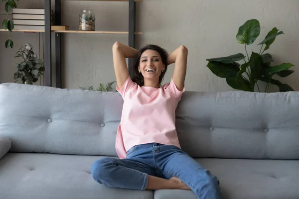 Portrait of happy ethnic female renter relax on couch — Stock Photo, Image