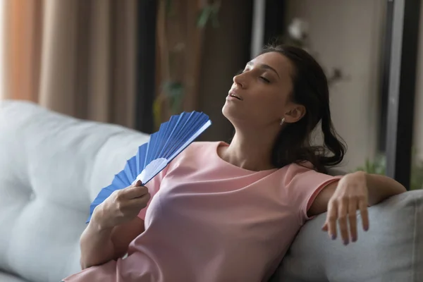 Nervózní etnická žena dýchá vzduch z ventilátoru — Stock fotografie