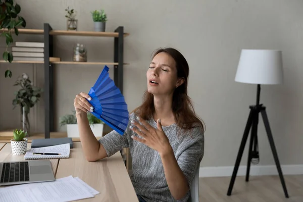 Overheated female wave with hand fan working at desk — Stock Photo, Image