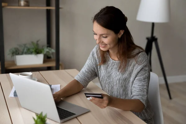 Uśmiechnięta kobieta robi zakupy online na laptopie w domu — Zdjęcie stockowe