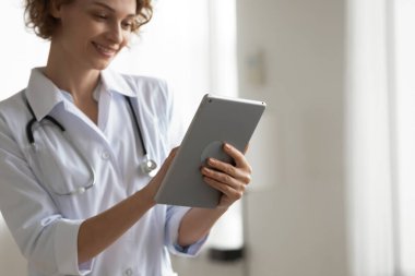 Genç kadın doktor ellerinde dijital bilgisayar tabletine odaklan.