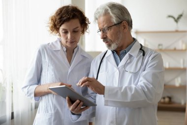 Bilgisayar tableti kullanan iki farklı jenerasyon doktoru..