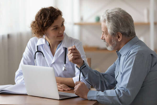 Serious middle aged retired man consulting with physician.