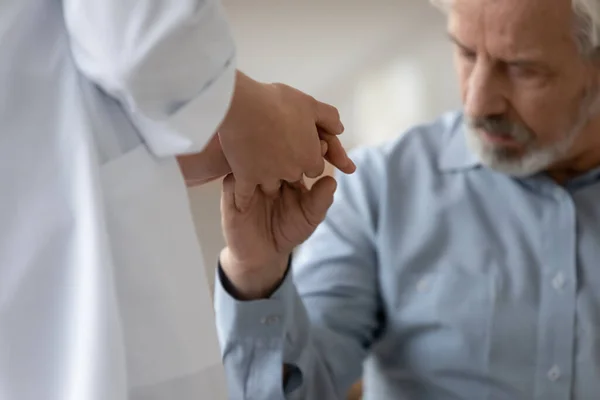 Jovem médica compassiva apoiando paciente mais velho. — Fotografia de Stock