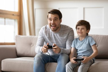 Mutlu baba ve küçük oğul video oyunu oynuyorlar.
