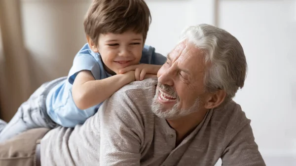 Happy boy play with smiling mature grandfather — Stock Photo, Image