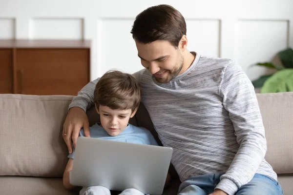 Pai feliz e filho pequeno usam laptop em casa — Fotografia de Stock