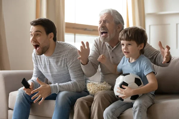 Три покоління чоловіків дивляться футбол вдома — стокове фото