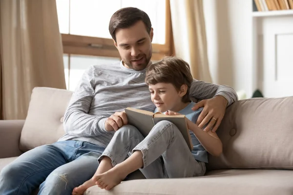Pai feliz e filho pequeno ler livro em casa — Fotografia de Stock