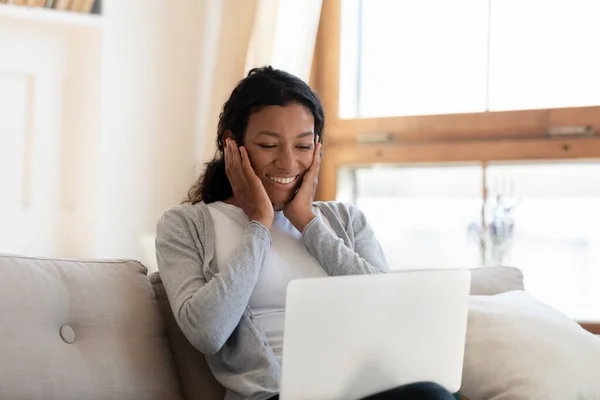 Emocionado joven feliz africana etnia mujer mirando a la pantalla de la computadora. — Foto de Stock