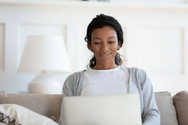 Jovem mulher afro-americana feliz usando computador em casa. — Fotografia de Stock