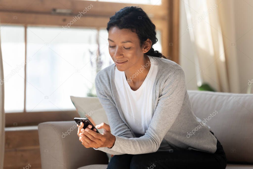 Smiling beautiful african american woman using smartphone.