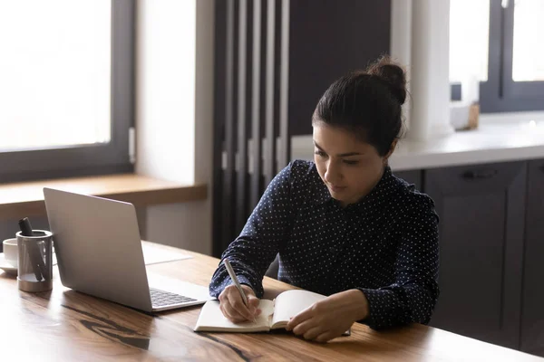 Focused donna indiana prendere appunti studiare online sul computer portatile — Foto Stock