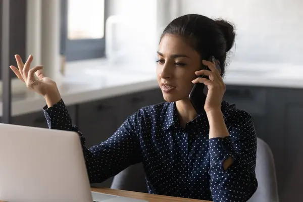 Indian woman worker work on laptop talk on smartphone — Stock Photo, Image