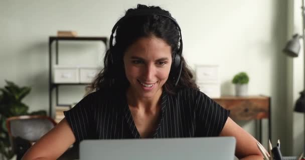 Woman wear headset working remotely using laptop and videocall app — Stock Video