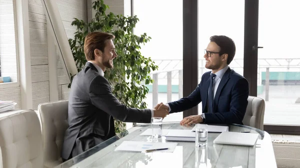 Smiling male business partners handshake at office meeting — Stock Photo, Image