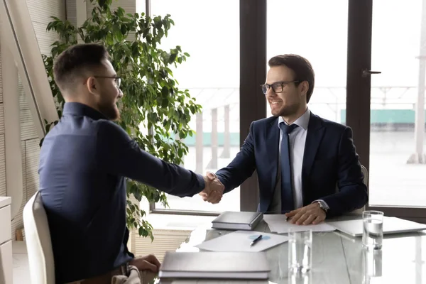 Sorridente multietnico uomini d'affari stretta di mano a riunione in ufficio — Foto Stock