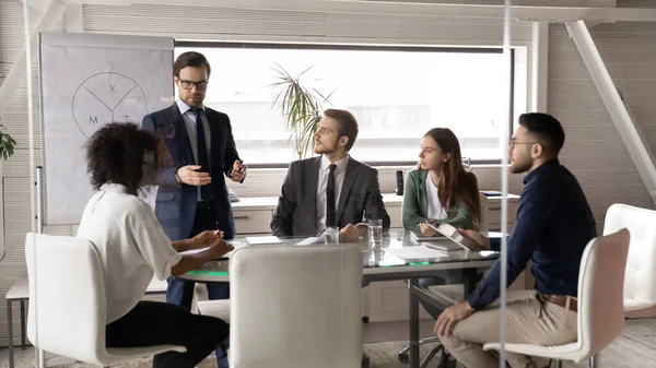 Zelfverzekerde mannelijke CEO maken flip-over presentatie op vergadering — Stockfoto