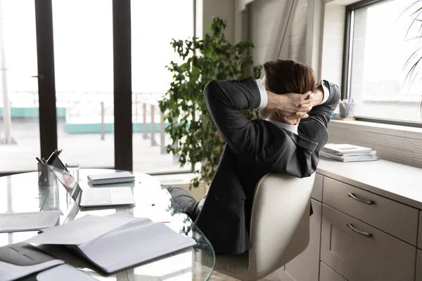 Vista trasera del tranquilo hombre de negocios relajarse en la silla en la oficina — Foto de Stock