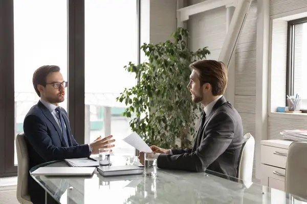 Serious businessmen talk discuss company paperwork at briefing — Stock Photo, Image