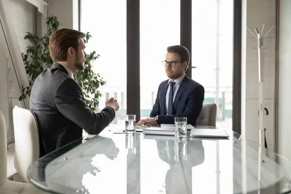 Hombres de negocios serios discuten ideas de negocios en la reunión de oficina —  Fotos de Stock