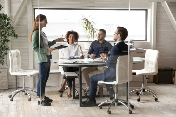 Kvinnlig anställd talar vid lagmöte med kollegor på kontoret — Stockfoto