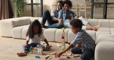 Afrikalı aile ve çocuklar hafta sonunu oturma odasında geçirirler.