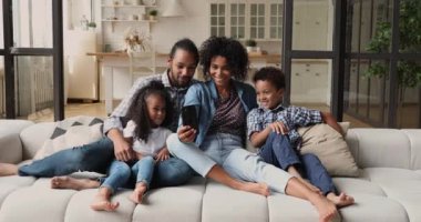 Afrikalı çiftler, küçük çocukları mobil uygulama kullanarak eğleniyorlar.