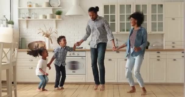 Afrikanska par och barn som håller händer hoppar i modernt kök — Stockvideo
