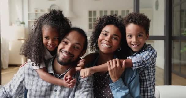 Szczęśliwa afrykańska rodzina z małymi dziećmi siedzącymi na kanapie — Wideo stockowe