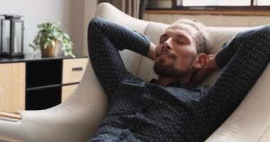 Rahat koltuğa yaslanmış, gevşeyen gözleri kapalı bir adam.