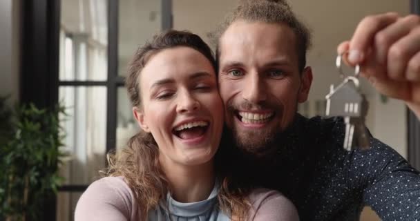 Happy married couple showing keys celebrate relocation to new house — Stock Video