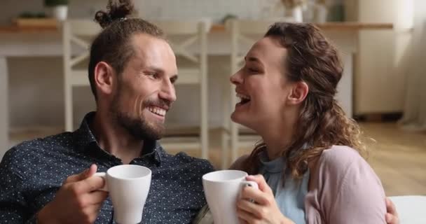 Para zakochanych rozmawia pijąc herbatę relaksując się na kanapie — Wideo stockowe