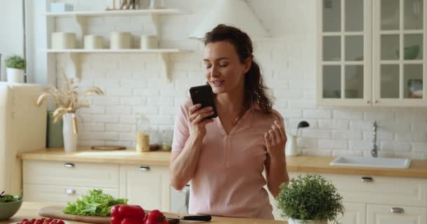 Žena v kuchyni pomocí virtuální asistent vyhledávání recepty na internetu — Stock video