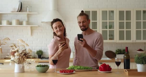 Pareja sosteniendo smartphones escuchando música cantando bailando disfruta de una cita romántica — Vídeos de Stock