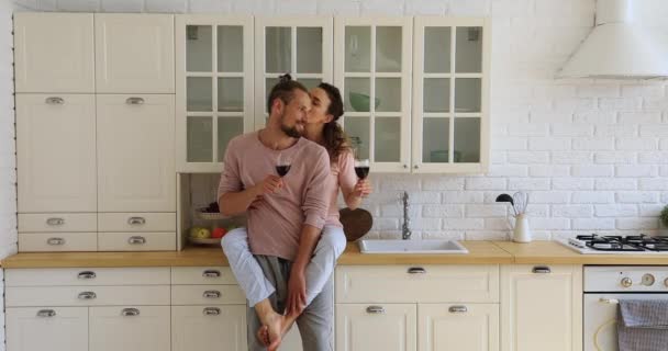 Пара смердючі окуляри з вином проводять дату на кухні — стокове відео