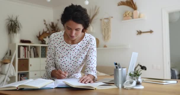 Mujer millennial inteligente concentrada leyendo libros educativos. — Vídeo de stock