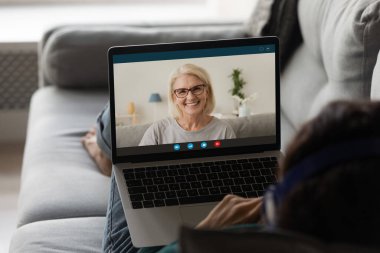 Kadın bilgisayar kullanıyor, web kamerasıyla konuşuyor.
