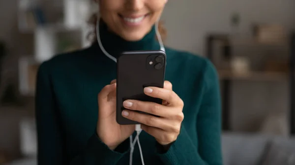 Close-up van vrouw in hoofdtelefoon gebruik smartphone — Stockfoto