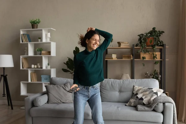 Gelukkig jong vrouw dansen in woonkamer met mobiele telefoon — Stockfoto