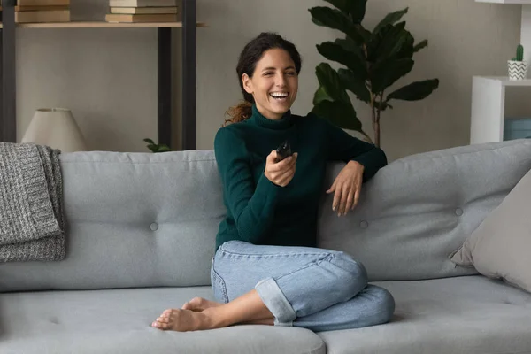 Glückliche Frau entspannt sich auf Couch vor dem Fernseher — Stockfoto