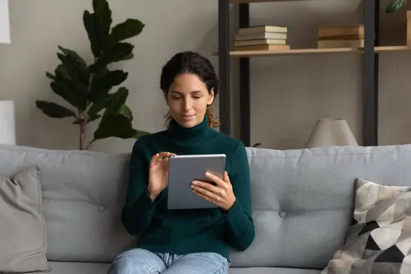 Mujer joven relajarse en el sofá usando gadget tableta — Foto de Stock