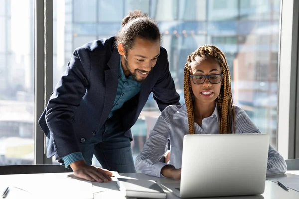 Lächelnde multiethnische Kollegen arbeiten gemeinsam am Laptop — Stockfoto